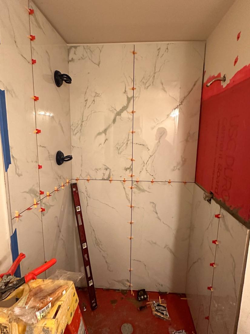 Large-format tile going up in a shower